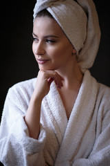 Young woman in a bathrobe and towel on her head, spa and care portrait, clean natural face