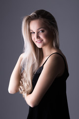 Fototapeta premium Close up studio portrait of a pretty blonde woman, smiling and looking at the camera