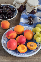 Juicy delicious ripe apricots and cherries on a plate.