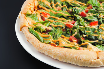 Delicious homemade italian pizza with fresh green salad,  tomato and cheese close up