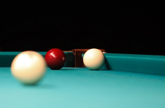 Playing billiard. Billiards balls and cue on green billiards tab