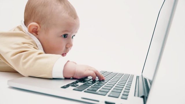 Serious baby works on a laptop