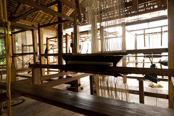 A close up image of an old weaving Loom and thread of yarn.
