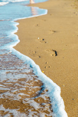 traces of a woman's legs on the sandy beach