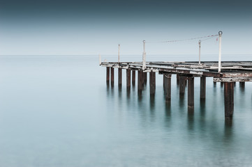 Old pier on the sea shore. Long exposure shoot