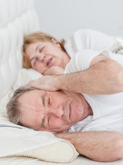 Sad senior man who can not sleep because his wife snores