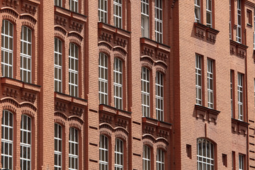 Fototapeta na wymiar Windows in a multi-storey brick building as a background