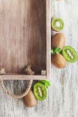 Green kiwis and mint leaves in the wooden tray
