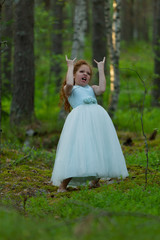 Obraz na płótnie Canvas Little emotional girl walks in a summer forest in a dress