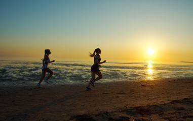 Fototapeta premium two girl running by the sea on the beach