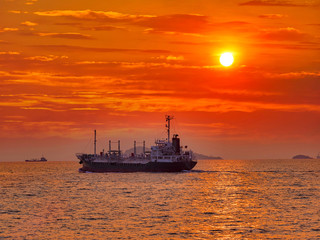 Fototapeta premium The tanker vessel(LPG) sailing for delivery LPG to industrial port of Thailand on silhouette