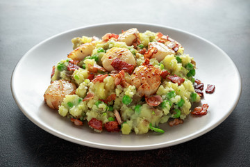 Fried scallops with mash potato, green peas and bacon