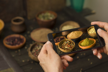 Food-blogger takes pictures on a smartphone spices for social networks.