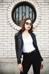 Fototapeta na wymiar Young woman posing in leather jacket