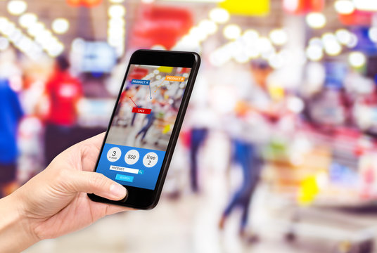 Hand hold mobile phone and using augmented reality ( AR ) app for see promotion sale in supermarket store,Digital lifestyle Technology concept.