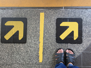 women feet in the sandal standing at the arrow sign on the BTS station