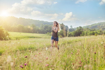Young woman jogging in the nature at sunset