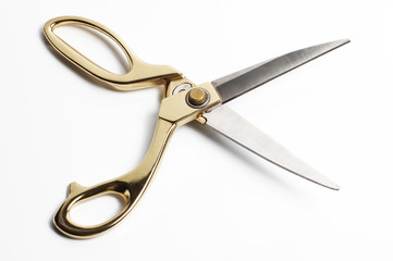 Gold scissors isolated on white background.