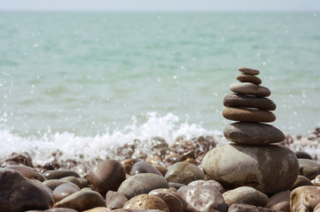 Pyramid of stones against the background of the sea with horizon