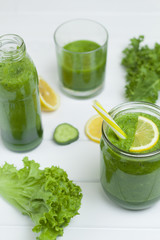 Green smoothies with vegetables, herbs and lemon on a white background. Healthy eating. Vegetarian cocktail.
