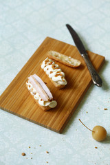 Traditional French Eclair with Apple Filling and Chantilly Cream, powdered with icing sugar, on light green background.
