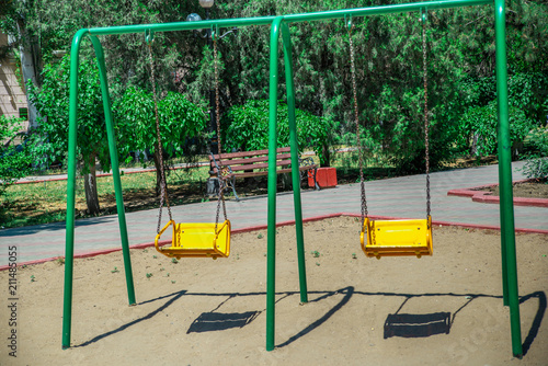Empty Baby Yellow Swing In The Park Stock Photo And Royalty