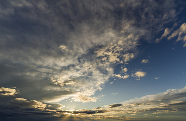 Fantastic panorama view of bright white gray dark wide puffy clouds lit by sun spreading against...