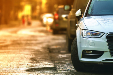 Close-up view of a new modern car parked on the side of the street. Soft ligtht effect. - obrazy, fototapety, plakaty