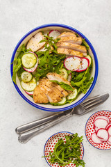 Fried chicken fillet and fresh vegetable salad of radish, arugula and cucumber. Grilled chicken breast salad. Healthy food.