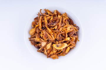 Deep fried shallots crisp / fried crispy onion flakes  (bawang goreng) in white bowl over wooden...