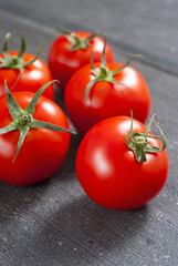 red tomatoes on old black wooden table