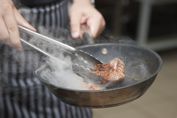 Hands chef cooking lamb