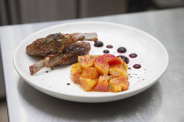 Hands chef cooking a lamb with a peach garnish