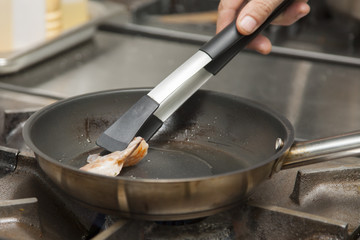 The hands of the cook, grilling shrimp