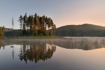 Magic reflections in the water of the dam. Sunrise in Rhodope mountain, Bulgaria. 