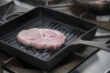 Hands cook cooking beef in a frying pan