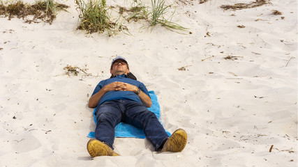 Mann liegt am Strand und erholt sich