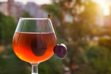 Fresh cherries with a glass on the nature background.