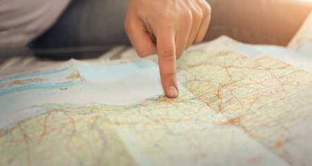 Close-up showing a man's finger pointing on paper map