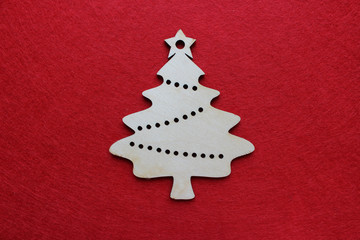 Handmade wooden Christmas tree on a red textured background, new year concept, empty space for...