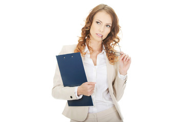 Thoughtful businesswoman with clipboard.