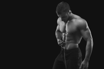 Fototapeta na wymiar Strong muscular man measuring waist