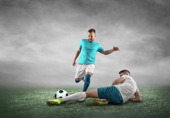 Soccer player on a football field in dynamic action at summer day