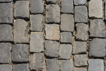 A top view of a paved road pattern. Masonry of the street. Sidewalk tiles.