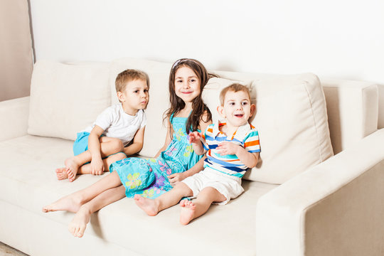 Photo of beautiful children on white modern couch.