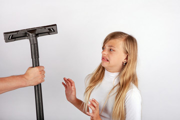 Hand holding a vacuum cleaner floor tool but the girl hates housework so she refuses it.