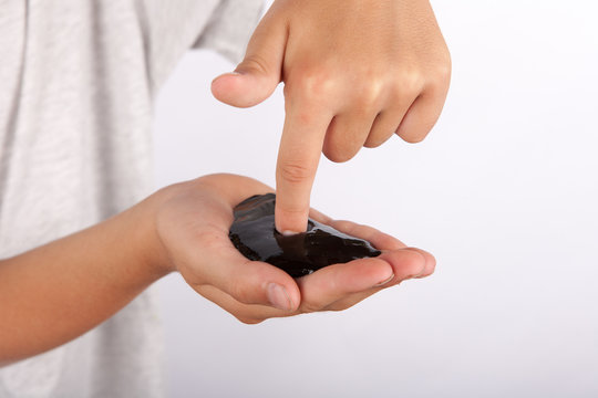 Young boy holding a black slime in his hand
