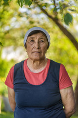 Naklejka na ściany i meble portrait of a sad elderly woman in the garden