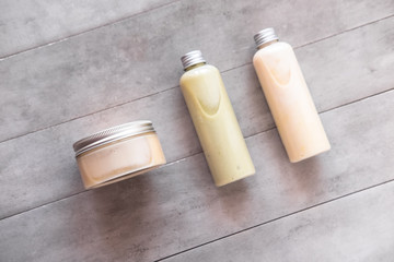 Bottles with spa cosmetic products from above on gray concrete table. Beauty blogger, salon treatments concept. Minimalism