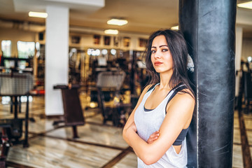 Sporty girl near punching bag in the gym